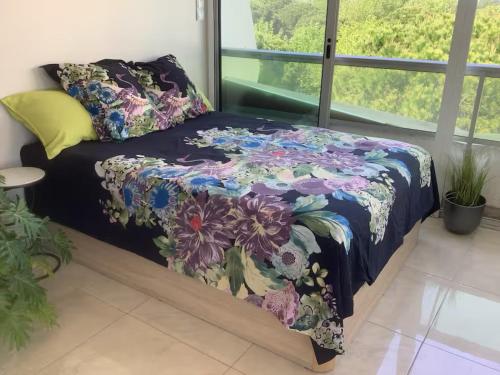 Ce lit se trouve dans un dortoir doté d'un couvre-lit floral. dans l'établissement Studio 34m2 avec la terrasse 60m2, aperçu mer, parking, Clim, plage à 150 m,Wi-fi, piscine, à La Grande Motte