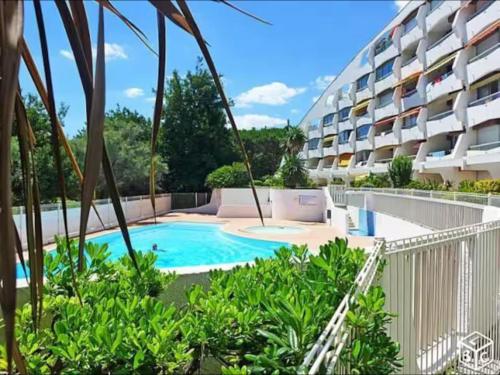 un appartement avec une piscine dans un bâtiment dans l'établissement Studio 34m2 avec la terrasse 60m2, aperçu mer, parking, Clim, plage à 150 m,Wi-fi, piscine, à La Grande Motte