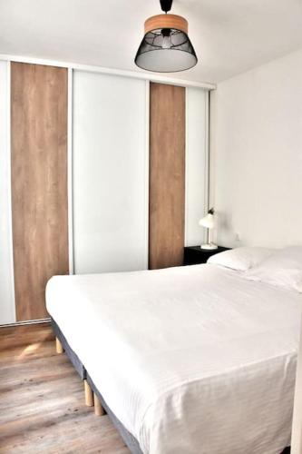 une chambre avec un grand lit blanc et des fenêtres dans l'établissement Hyper Centre - Élégant Appartement au Pied des Restaurants et Boutiques, à Caen