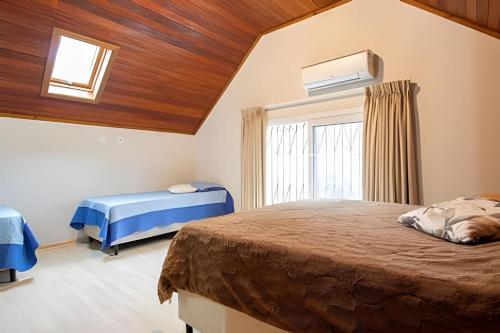 a bedroom with two beds and a window at Rosa Casa Morar da Serra in Canela
