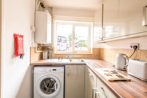 una cucina con lavatrice e lavandino di Temple Wall - Contractors, Families - FREE PARKING by Prescott Apartments a Bristol