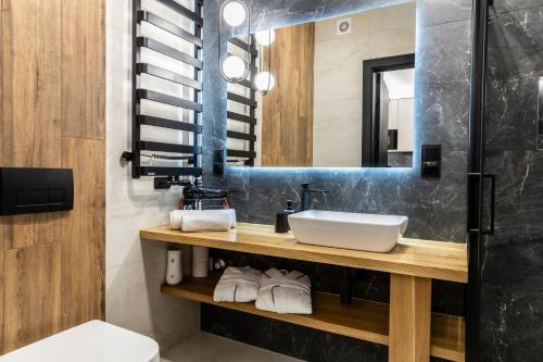 a bathroom with a sink and a mirror at Apartamenty Bujaś Resort - Białka Spa Resort in Białka Tatrzanska