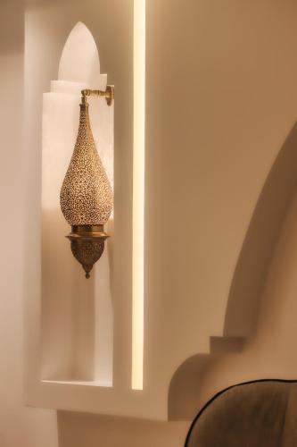 a lamp on a wall in a room at TAJ CHEFCHAOUEN Luxury Hotel and Spa in Chefchaouen