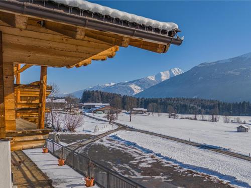a ski lodge with a snow covered mountain in the background at Premium Apartment Edelweiß in Hollersbach im Pinzgau