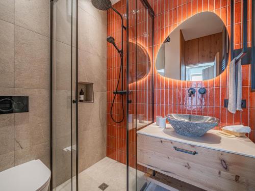 a bathroom with a sink and a shower with a mirror at Premium Apartment Edelweiß in Hollersbach im Pinzgau