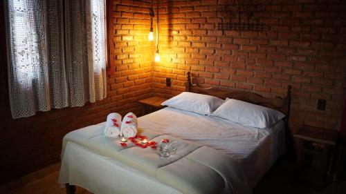 a bedroom with a bed with shoes on it at Chalés Ouro de Minas in Conceição da Ibitipoca