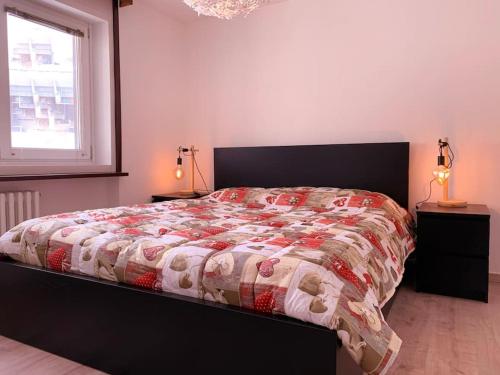 a bedroom with a bed with a comforter and a window at Appartamento centralissimo ski in - ski out in Breuil-Cervinia