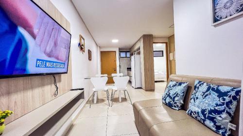 a living room with a couch and a flat screen tv at Eco Summer Tambaú WB Genius Flats in João Pessoa