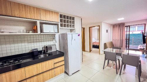a kitchen with a refrigerator and a table in it at Eco Summer Tambaú WB Genius Flats in João Pessoa