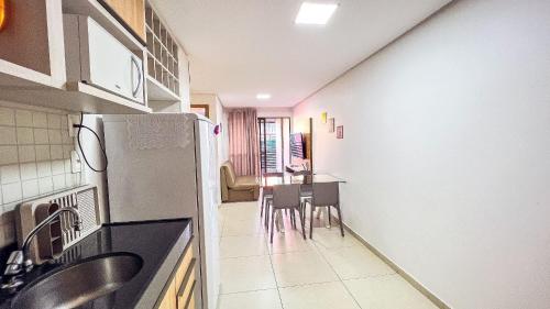 a kitchen with a refrigerator and a table and chairs at Eco Summer Tambaú WB Genius Flats in João Pessoa