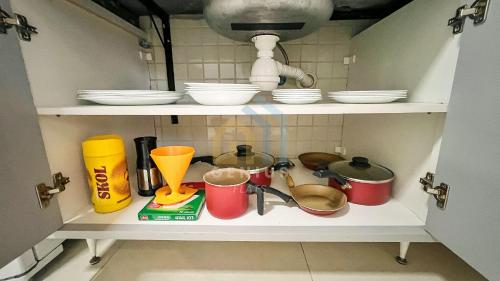 a shelf with dishes and utensils in a kitchen at Eco Summer Tambaú WB Genius Flats in João Pessoa