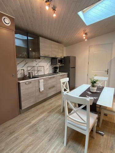 une cuisine avec une table et des chaises dans une pièce dans l'établissement Chez Pascal Sissi -Au Coeur de Vignes, parking free, à Châteauthébaud