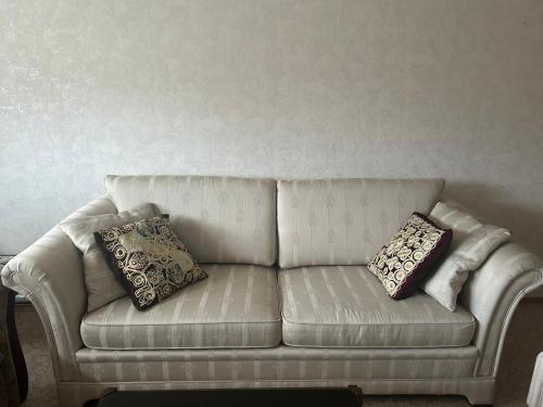 a white couch with two pillows on it at Apartment 136 m2 with 3 bedrooms and 2 livingrooms, 2 floors, walking distance to all amenities in Närpiö