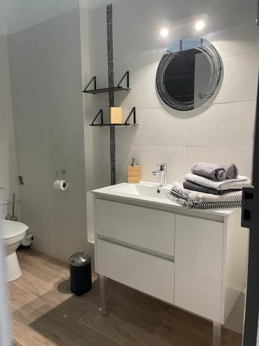 une salle de bain blanche avec un lavabo et un miroir dans l'établissement La belle époque, à Dinard