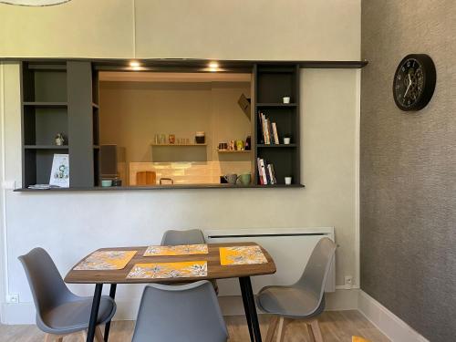 une salle à manger avec une table, des chaises et un miroir dans l'établissement La belle époque, à Dinard