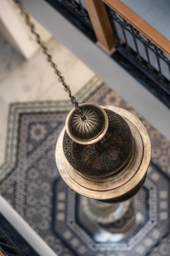 a vase hanging from a chain on a wall at TAJ CHEFCHAOUEN Luxury Hotel and Spa in Chefchaouen