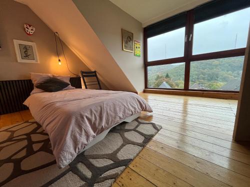 ein Schlafzimmer mit einem Bett und einem großen Fenster in der Unterkunft Ferienhaus Brinker Bleibe in Velbert