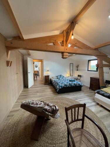 Cette grande chambre comprend un lit et une chaise. dans l'établissement Oasis de verdure en Périgord - vue imprenable, à Lamonzie-Montastruc