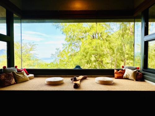 a room with a large window with pillows and shoes at Zephyr Homestay in Yanliau
