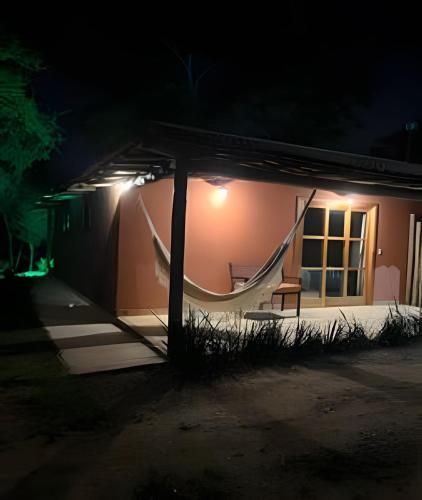 a house with a hammock outside at night at Sítio Santo Antônio - Chalé 1 com Ofurô in Atibaia