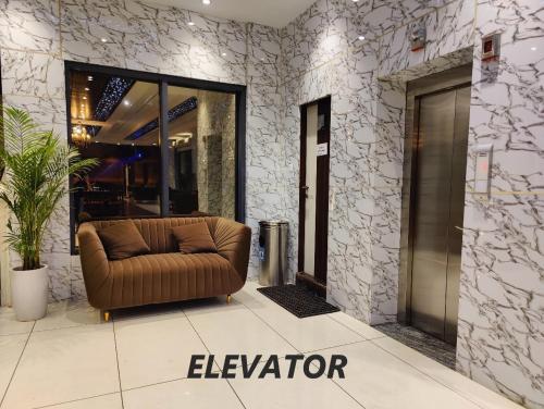 a brown couch sitting in the middle of a lobby at Hotel Mandi Heights - Bar, Fine Dining & Banquet Hall in Mandi