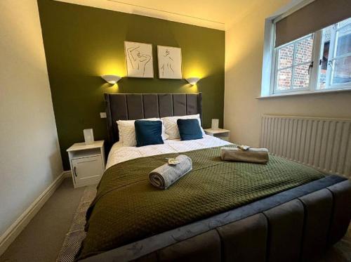 a bedroom with a large bed with two towels on it at Queen Anne Court with FREE PARKING By Prescott Apartments in Abingdon