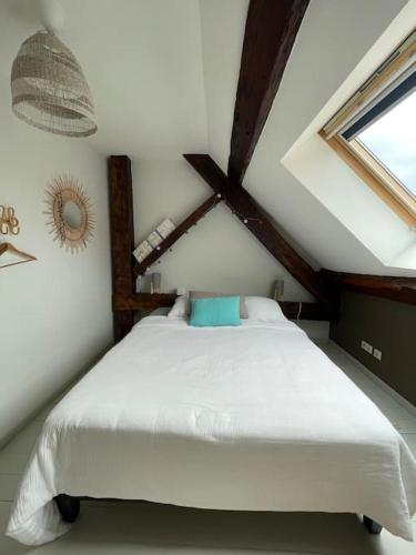 une chambre avec un lit blanc dans un grenier dans l'établissement Appartement, à Vesoul