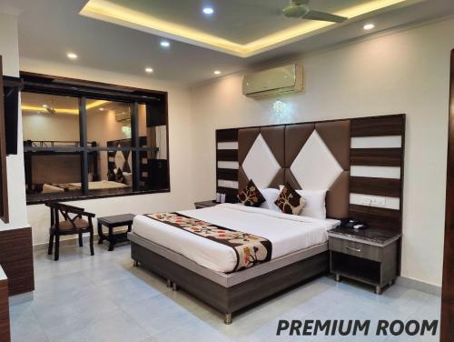 a bedroom with a large bed and a desk and a window at Hotel Mandi Heights - Bar, Fine Dining & Banquet Hall in Mandi