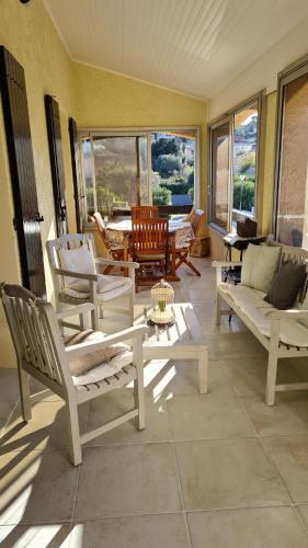 un salon avec des chaises blanches et une table dans l'établissement clamart, à Sanary-sur-Mer