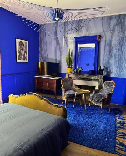 a bedroom with blue walls and a bed and a desk at Manoir la grande guerais in Beaussais sur Mer