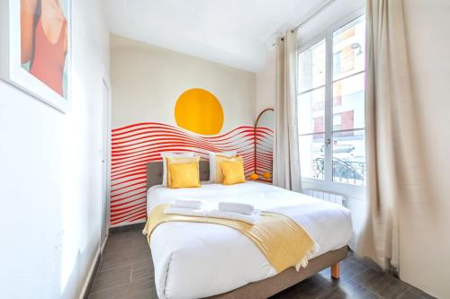 - une chambre avec un grand lit aux accents jaunes et rouges dans l'établissement Appartement relaxant #Montparnasse 4 personnes, à Paris