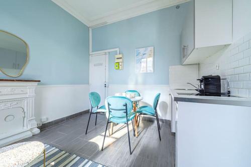 une cuisine avec des chaises bleues et une table dans l'établissement Appartement relaxant #Montparnasse 4 personnes, à Paris