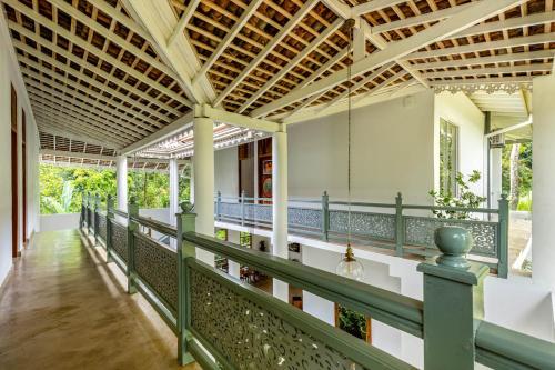 an external view of the porch of a house with a green railing at Samalanka Boutique Hotel in Habaraduwa