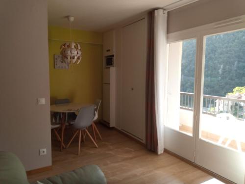 d'un salon avec une table et un balcon. dans l'établissement Amélie les bains Exposition SUD Gorges du Mondony 6éme étage, à Amélie-les-Bains-Palalda