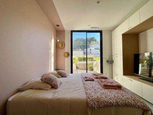 une chambre avec un grand lit et une grande fenêtre dans l'établissement Le Loft de Mel à l'Estaque - atypique & vue mer, à Marseille