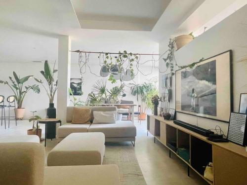 - un salon avec un canapé, des fauteuils et des plantes dans l'établissement Le Loft de Mel à l'Estaque - atypique & vue mer, à Marseille