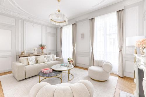 un salon avec un canapé, une table et des chaises dans l'établissement Artistic Luxury 3-Bedroom Apartment - Champs-Élysées, à Paris