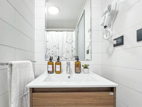 a bathroom with a sink with two bottles on it at Depto nuevo 5 estrellas, ubicación insuperable in Puerto Varas