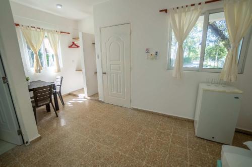 a room with a table and a door and a dining room at Bungalow #15 at Waterfront Playa Alicia in Sosúa