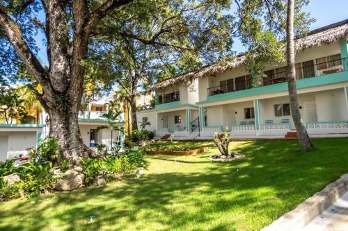 an exterior view of a building with a green yard at Bungalow #15 at Waterfront Playa Alicia in Sosúa