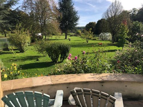 two chairs in a garden with a field of flowers at Chez Manon et Martin - Chambre à la campagne avec Spa extérieur in Saâcy-sur-Marne