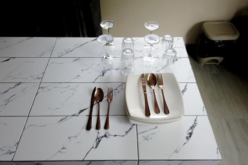 a table with wine glasses and cutlery on it at Logan's Paradise Vacation Home in Tena