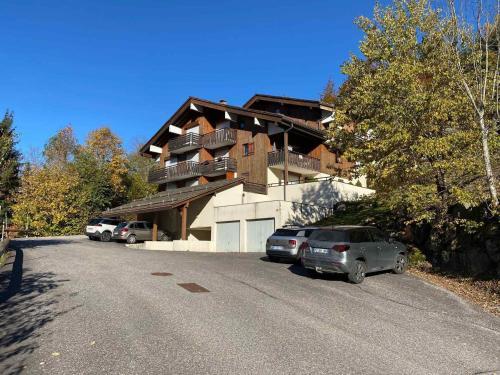 un bâtiment avec des voitures garées sur le côté de la route dans l'établissement 2 pièces avec balcon et parking à La Clusaz - FR-1-459-92, à La Clusaz