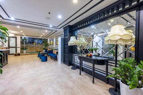 ハノイにあるHanoi Central Hotel & Residencesのデスクとテーブル付きのオフィスロビー