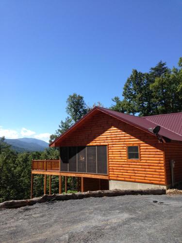 a log cabin with a porch and a deck at summers dream log cabin in Luray
