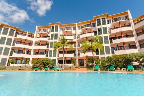 a resort with a swimming pool in front of a building at Varandas Funchal-Near center in Funchal
