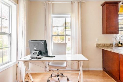 a desk with a computer on it in front of a window at Luxurious & Comfy Private Room in DC in Washington