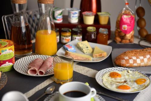a table topped with plates of breakfast foods and drinks at Les chambres du Palais Bastia Centre in Bastia
