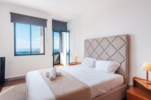 a bedroom with a large bed with a large window at Varandas Funchal-Near center in Funchal