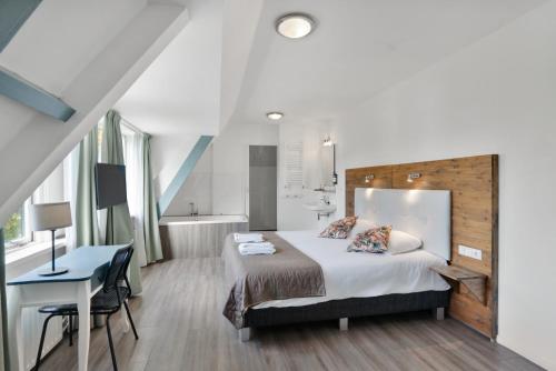 a bedroom with a bed and a desk and a sink at Dijkstra Hotels in Bergen